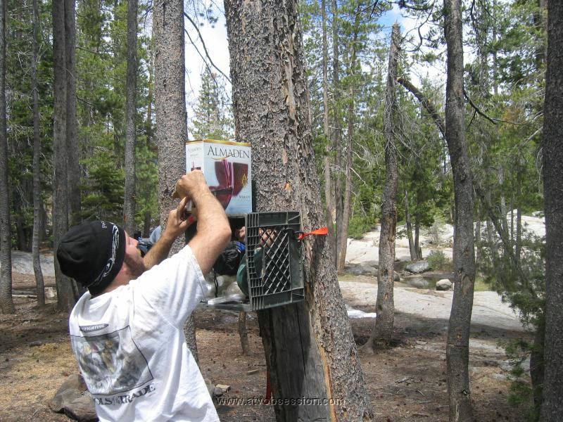 058. Dusty straps his Milk Carton to a tree with his box of wine..jpg